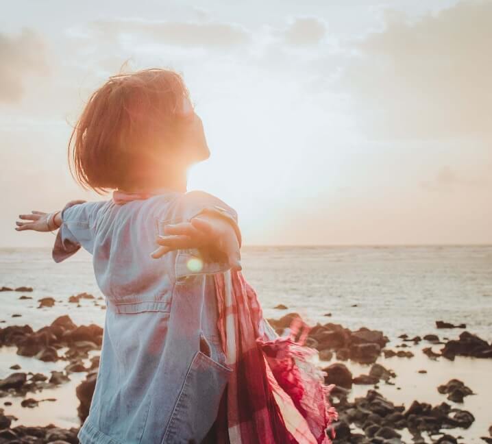 Frau am Strand im Sonnenuntergang