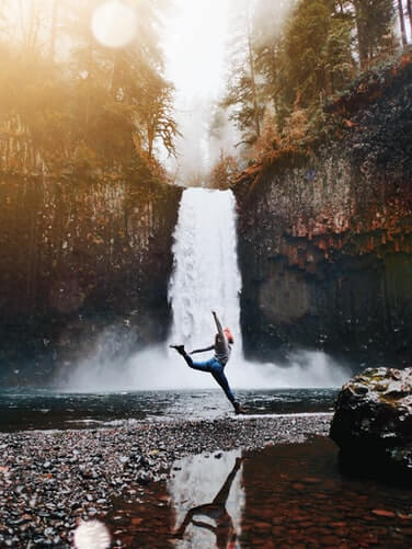 Frau vor Wasserfall